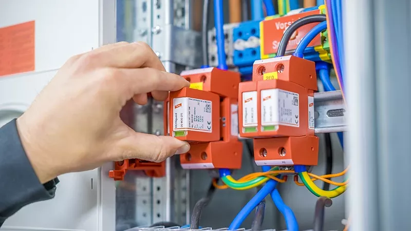 Hand installing the DEHNguard surge arrester in the switch cabinet